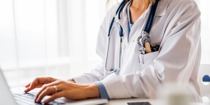 female doctor typing patient notes