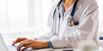 female doctor typing patient notes