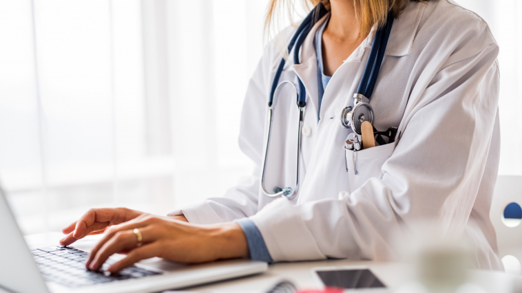 female doctor typing patient notes